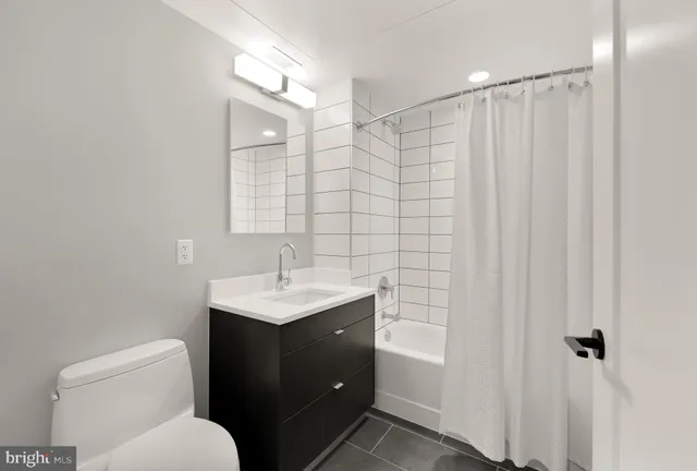 a bathroom with a toilet sink vanity and mirror