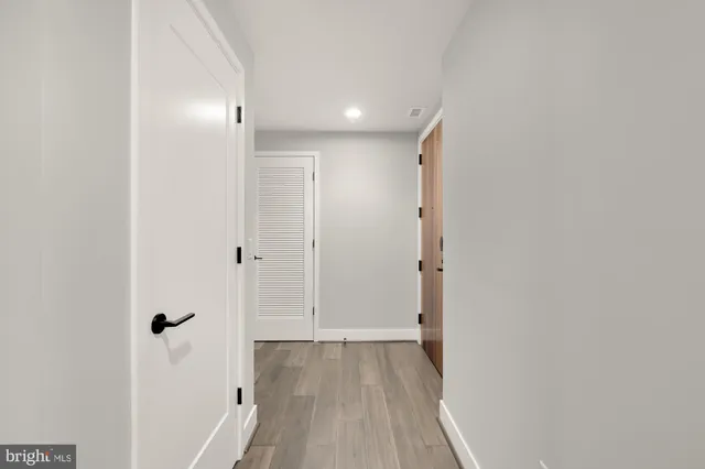 a view of a hallway with wooden floor