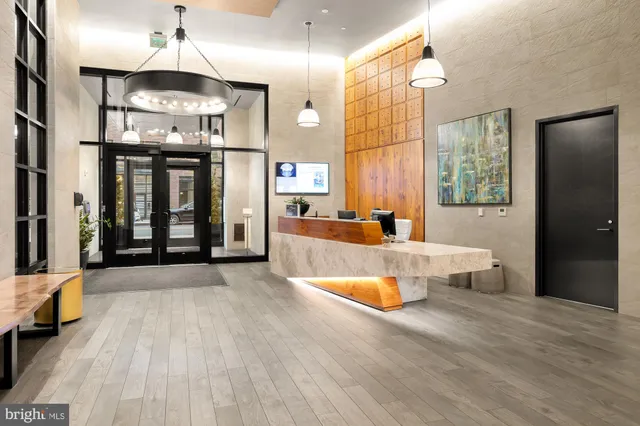 a large kitchen with stainless steel appliances a large counter top a stove and a refrigerator