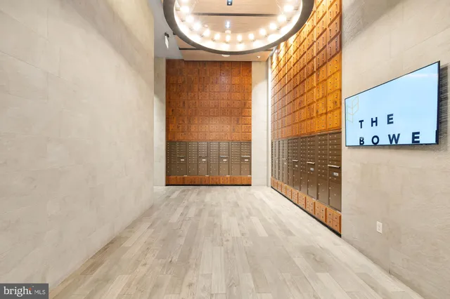a view of an empty room with a window and kitchen view