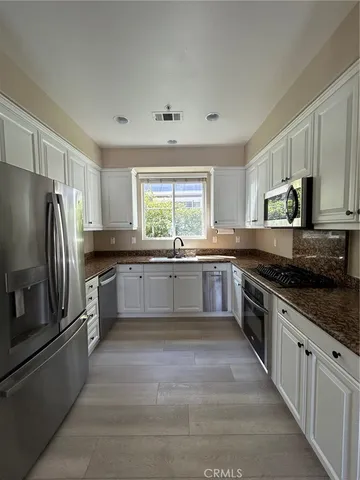a large kitchen with a stove top oven a refrigerator and a sink