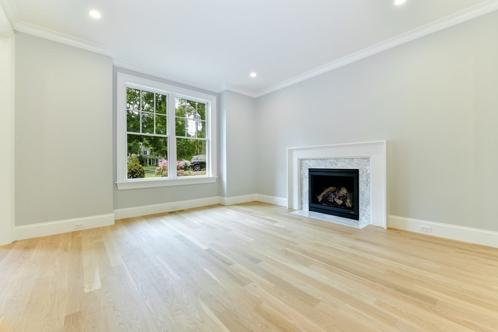 Lot 25 Leewood Road Wellesley, MA 02482 - Photo 13 of 40 an empty room with wooden floor a fireplace and windows