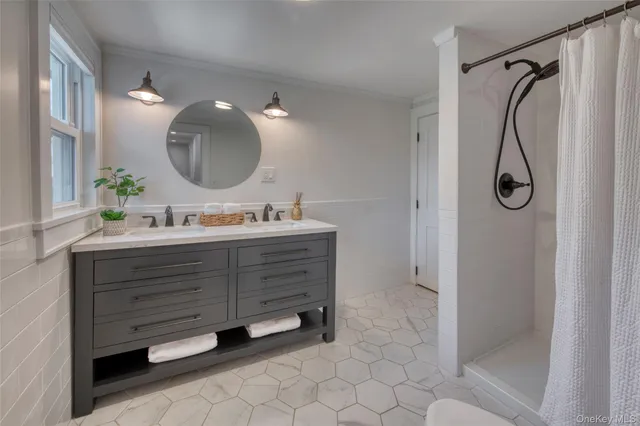 a bathroom with a double vanity sink mirror and shower