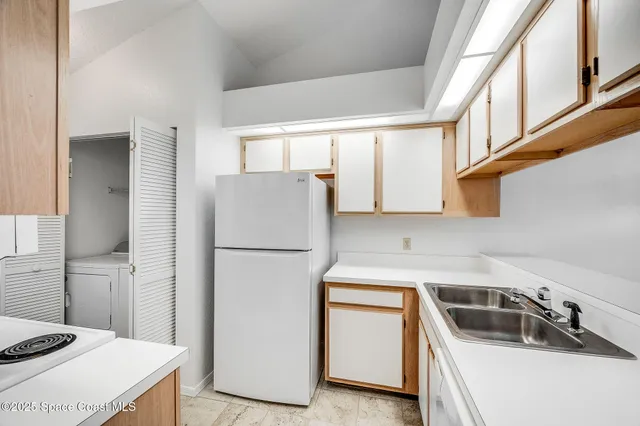 a kitchen with a refrigerator sink and cabinets