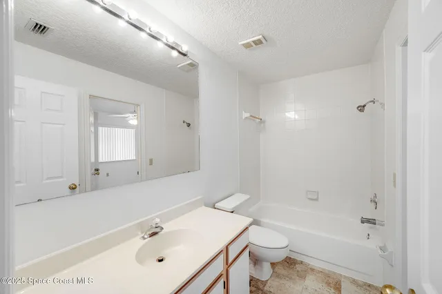a bathroom with a bathtub shower sink vanity mirror and toilet