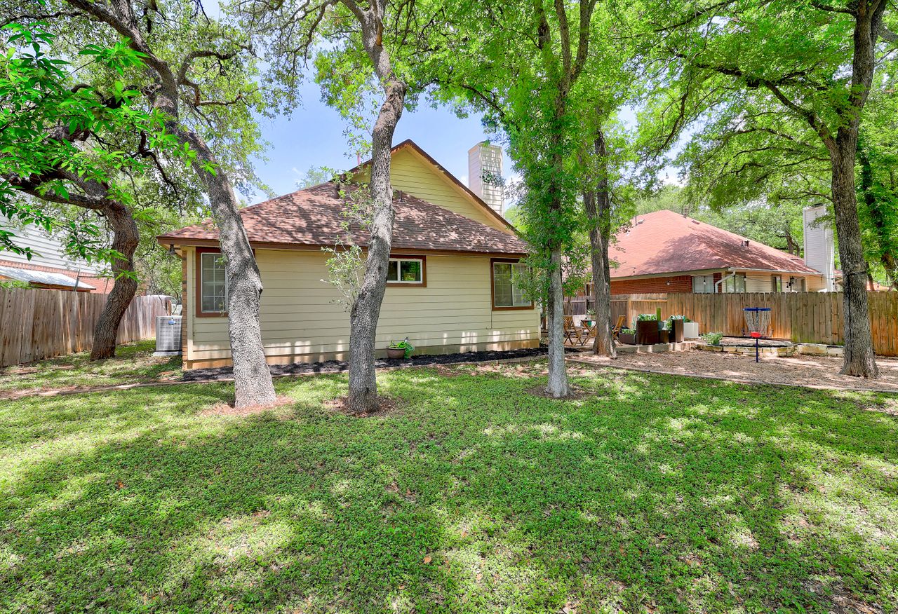 5907 Shanghai Pierce Road Austin, TX 78749 - Photo 28 of 29 Back of property featuring a fenced backyard, a chimney, and roof with shingles