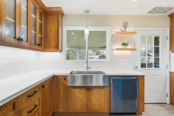 a large kitchen with stainless steel appliances kitchen island granite countertop a refrigerator and a stove top oven