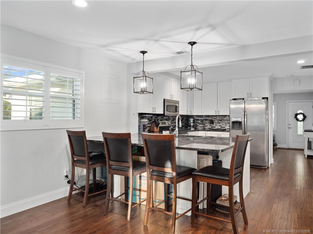 1544 Northwest Spruce Ridge Drive Stuart, FL 34994 - Photo 8 of 23 a view of a dining room with furniture window and wooden floor