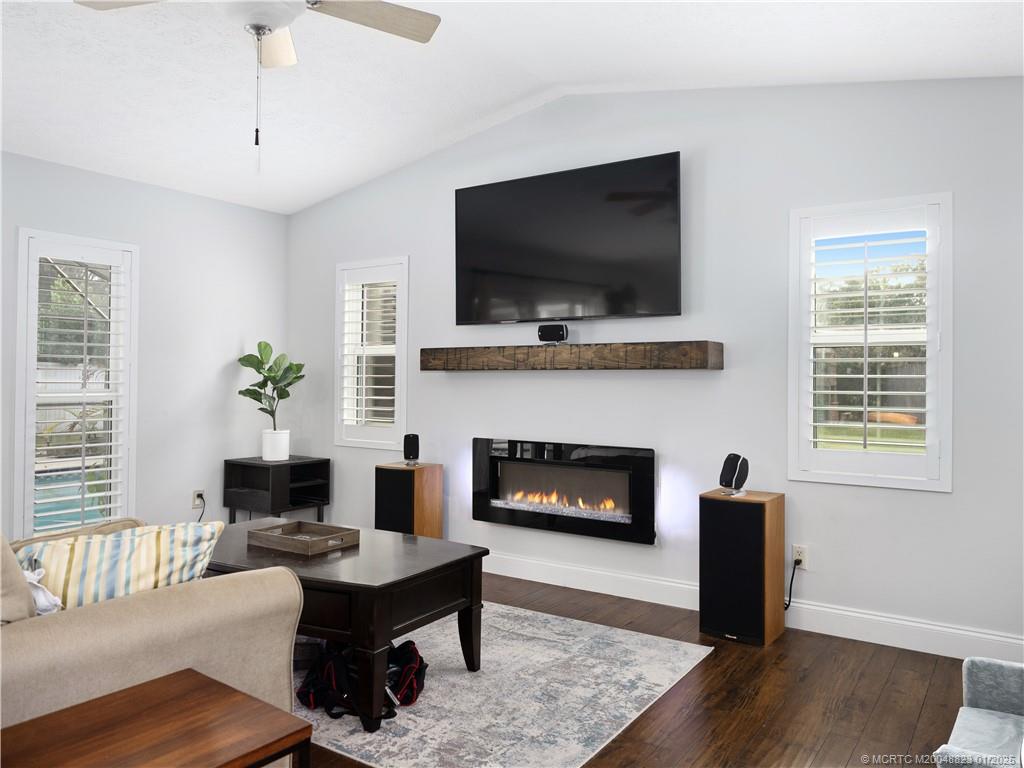 1544 Northwest Spruce Ridge Drive Stuart, FL 34994 - Photo 10 of 23 a living room with furniture a flat screen tv and a fireplace