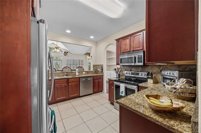 a kitchen with stainless steel appliances granite countertop a sink stove and refrigerator