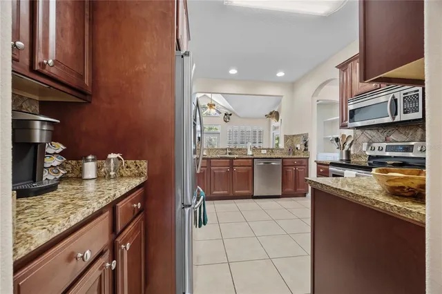 a kitchen with stainless steel appliances granite countertop a sink stove and cabinets