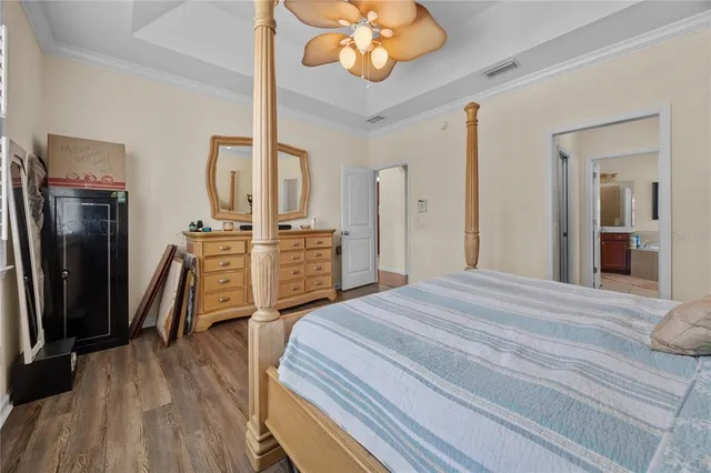 a bedroom with bed and wooden floor