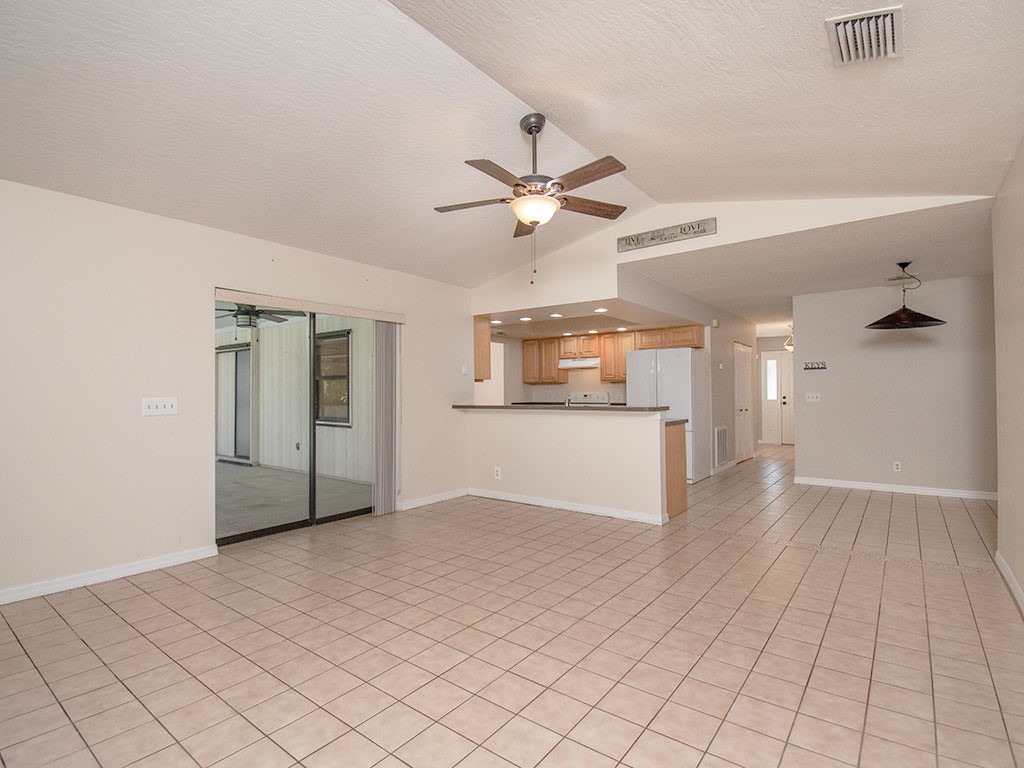 124 Hinchman Avenue Sebastian, FL 32958 - Photo 12 of 31 a view of a kitchen with wooden cabinet and a refrigerator