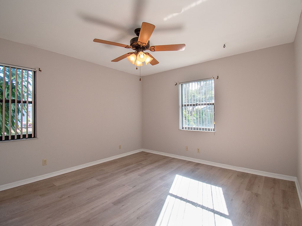 124 Hinchman Avenue Sebastian, FL 32958 - Photo 17 of 31 an empty room with wooden floor fan and windows