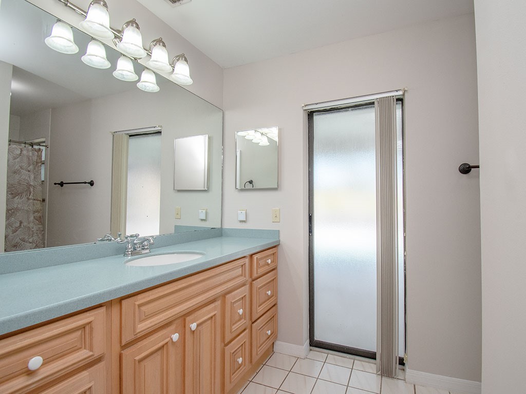 124 Hinchman Avenue Sebastian, FL 32958 - Photo 19 of 31 a bathroom with a granite countertop sink a large mirror and a shower