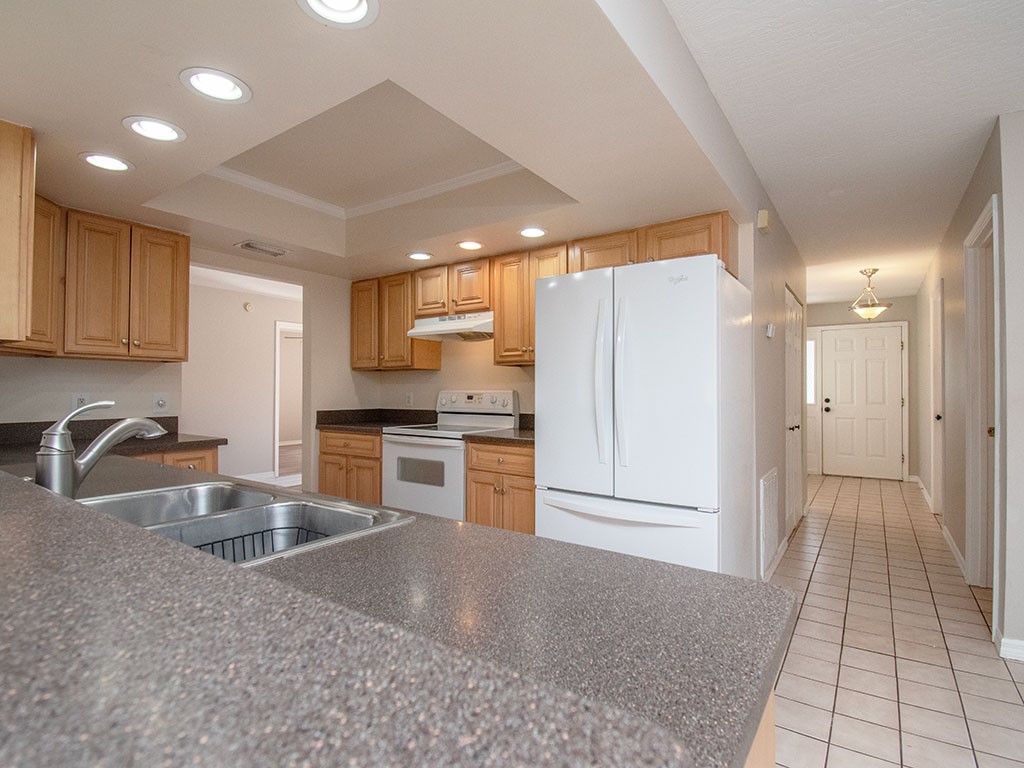 124 Hinchman Avenue Sebastian, FL 32958 - Photo 9 of 31 a kitchen with granite countertop a refrigerator and a sink