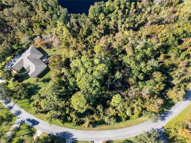an aerial view of residential house with parking and yard
