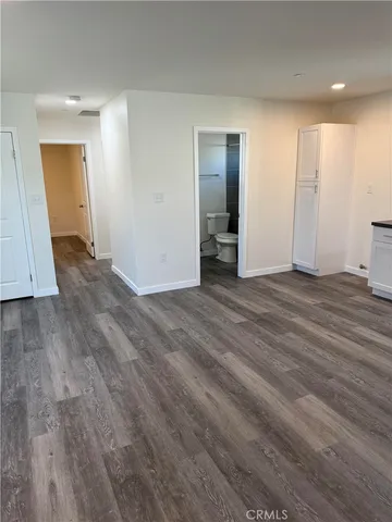 an empty room with wooden floor and closet