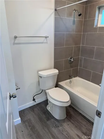 a white toilet sitting next to a white tub
