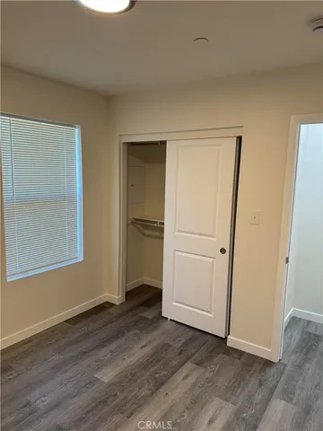 an empty room with wooden floor and closet