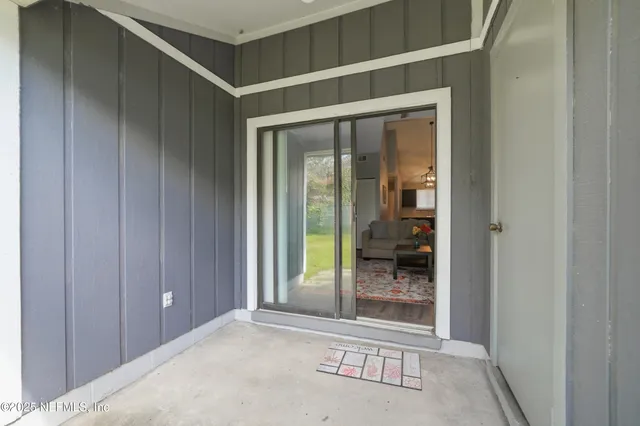 a view of a room that has a large window and front door