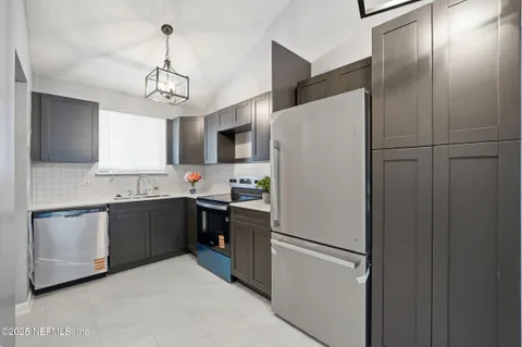 a white refrigerator freezer and a stove sitting inside of a kitchen