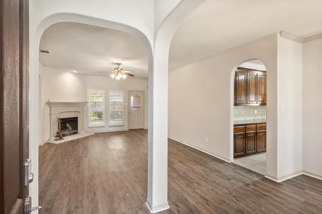 a view of an empty room with window and cabinet area