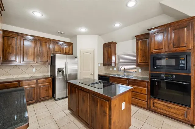 a kitchen with granite countertop a sink and a stove