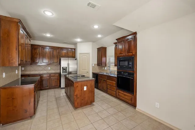 a kitchen with refrigerator cabinets and stainless steel appliances