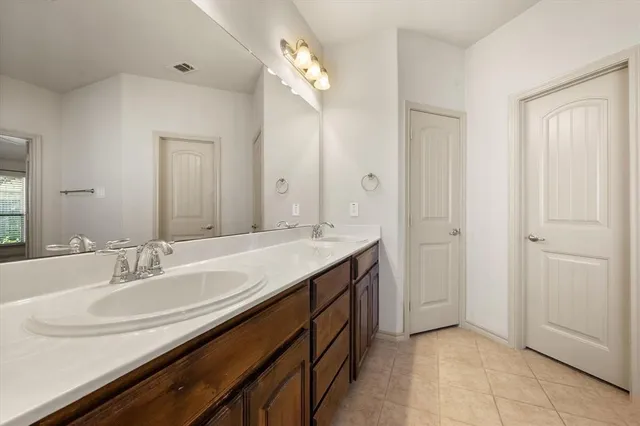 an empty room with a chandelier fan and windows