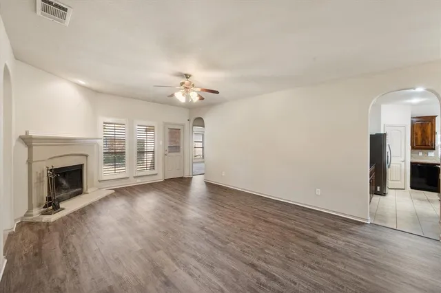 an empty room with wooden floor and fireplace