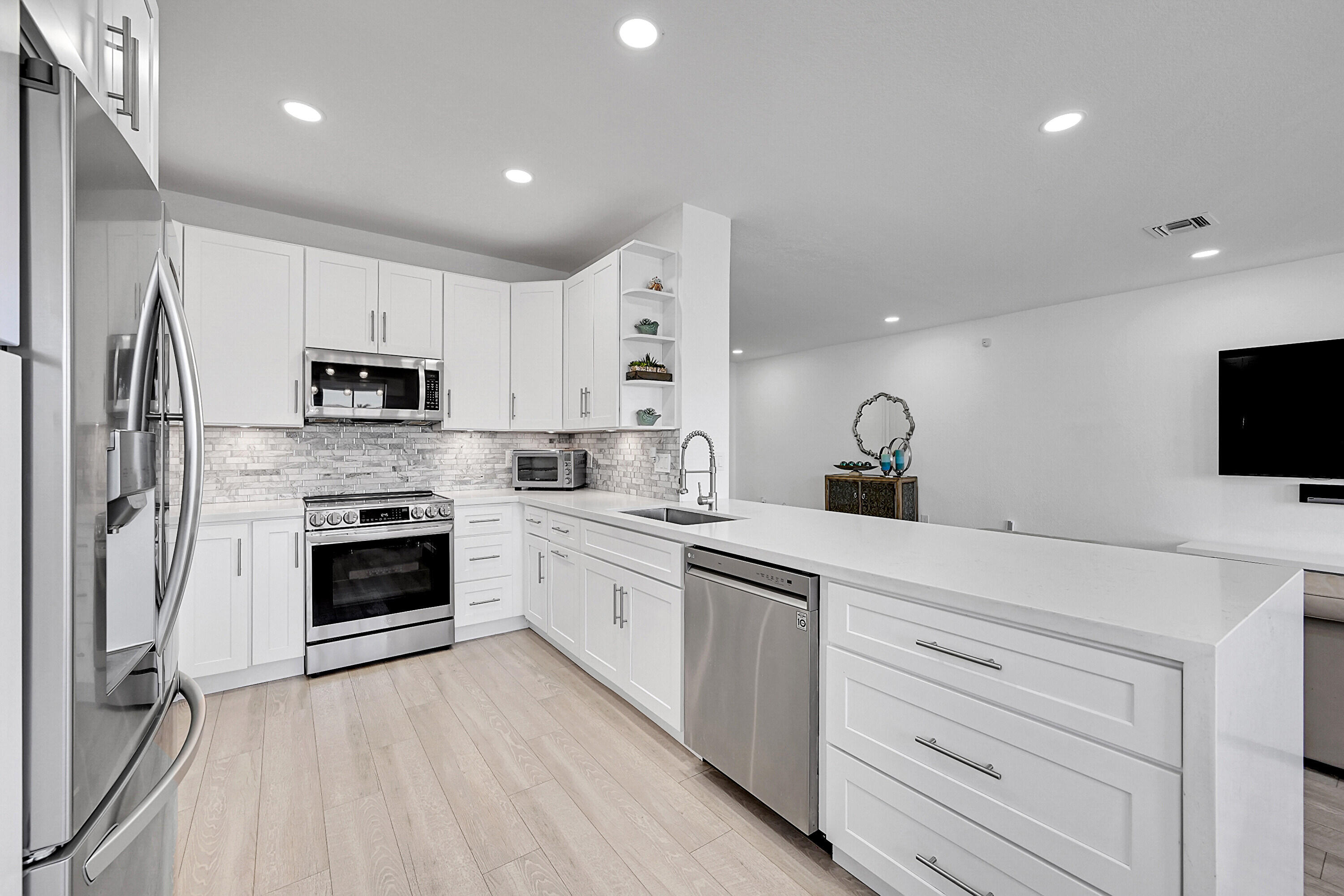 8459 Lakeview Trail Parkland, FL 33076 - Photo 17 of 55 a kitchen with white cabinets and stainless steel appliances