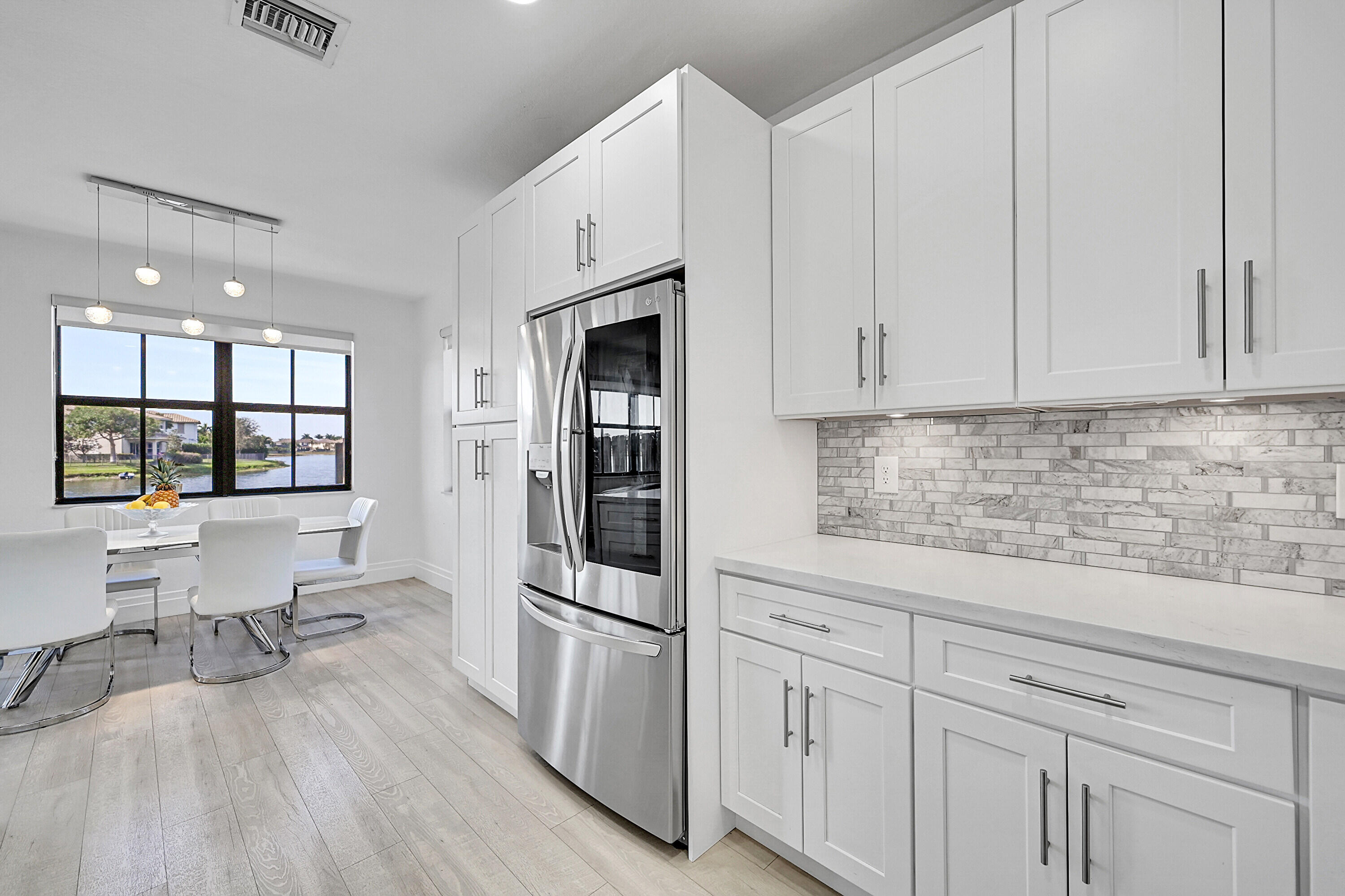 8459 Lakeview Trail Parkland, FL 33076 - Photo 19 of 55 a kitchen with white cabinets and white appliances