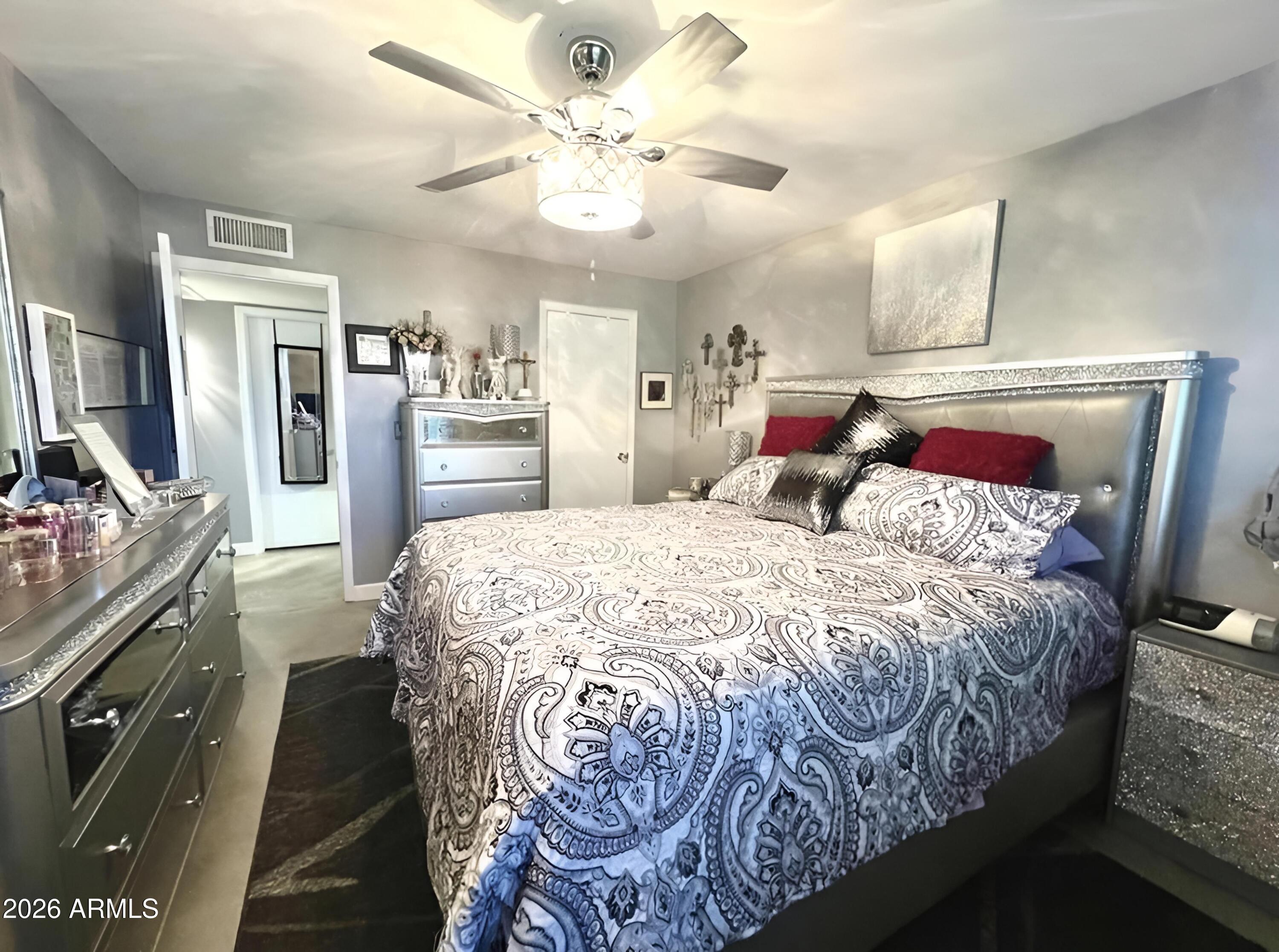 3425 East Libby Street Phoenix, AZ 85032 - Photo 10 of 16 a bedroom with a large bed and a chandelier
