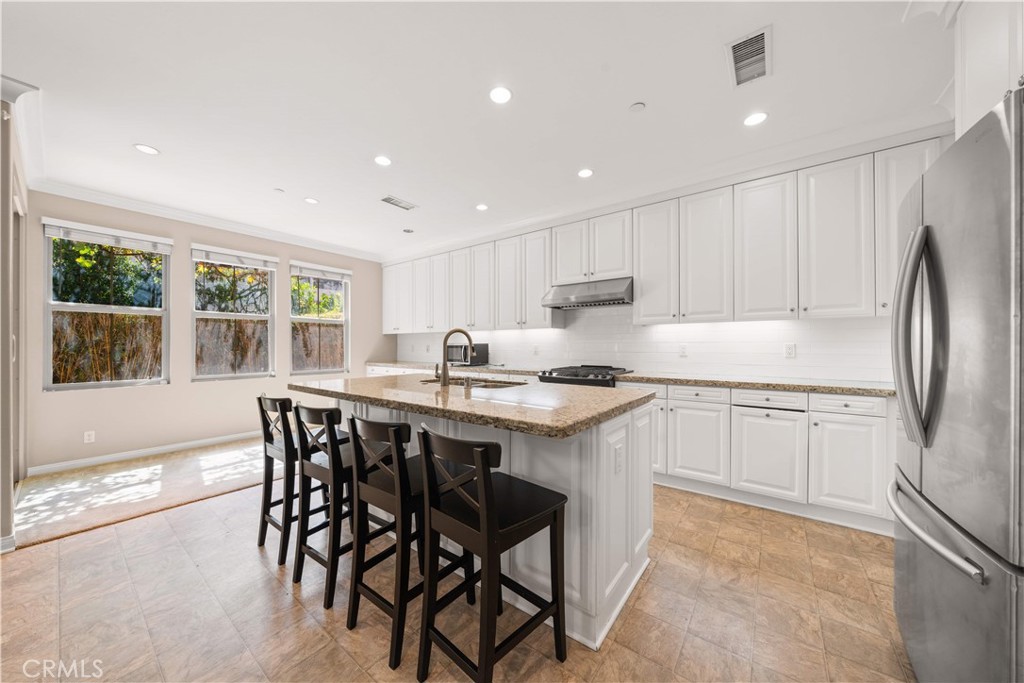 129 Overbrook Irvine, CA 92620 - Photo 13 of 41 a kitchen with kitchen island granite countertop wooden floors appliances and window
