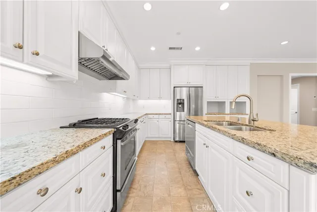 a large kitchen with stainless steel appliances granite countertop a stove a sink and a granite counter tops