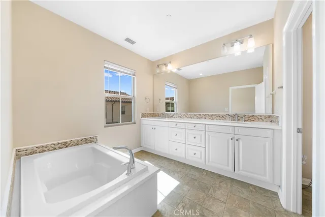 a bathroom with a granite countertop sink mirror and bathtub