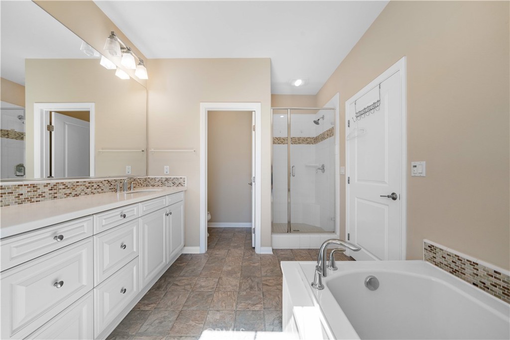 129 Overbrook Irvine, CA 92620 - Photo 32 of 41 a bathroom with a granite countertop double vanity sink a mirror and a bathtub