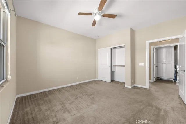 a view of an empty room with a ceiling fan