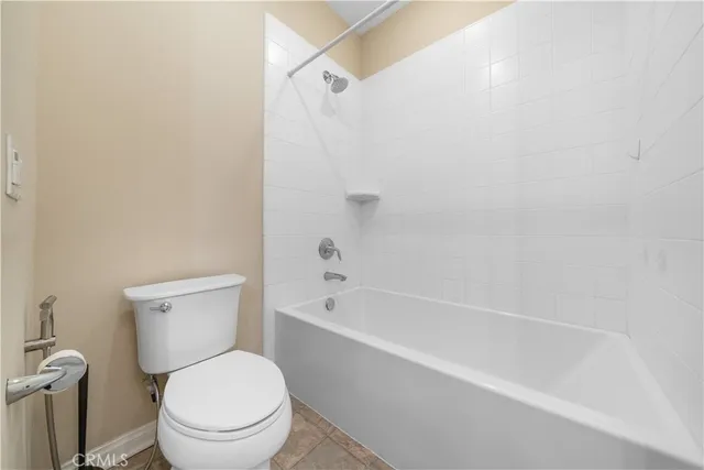 a white toilet and tub sitting next to a bathroom sink