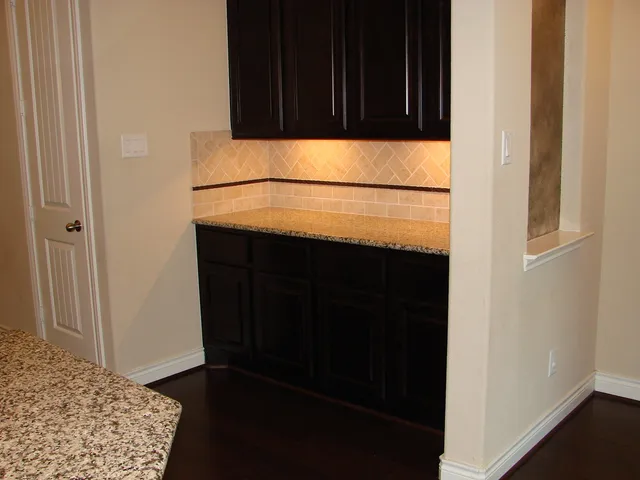 a kitchen with a sink a refrigerator and wooden floor
