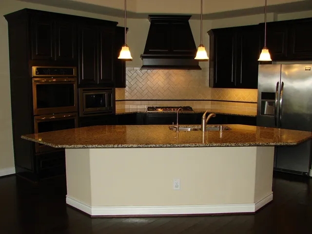 a kitchen with a sink a counter top with stove and chairs