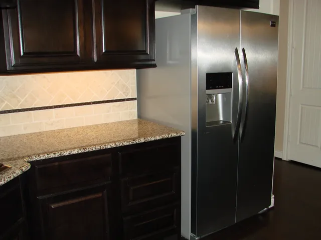 a view of an empty room with wooden floor fireplace and a window