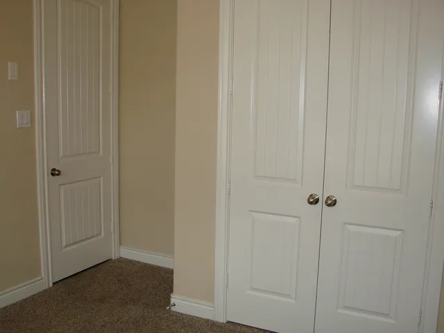 a view of a hallway with wooden floor and closet