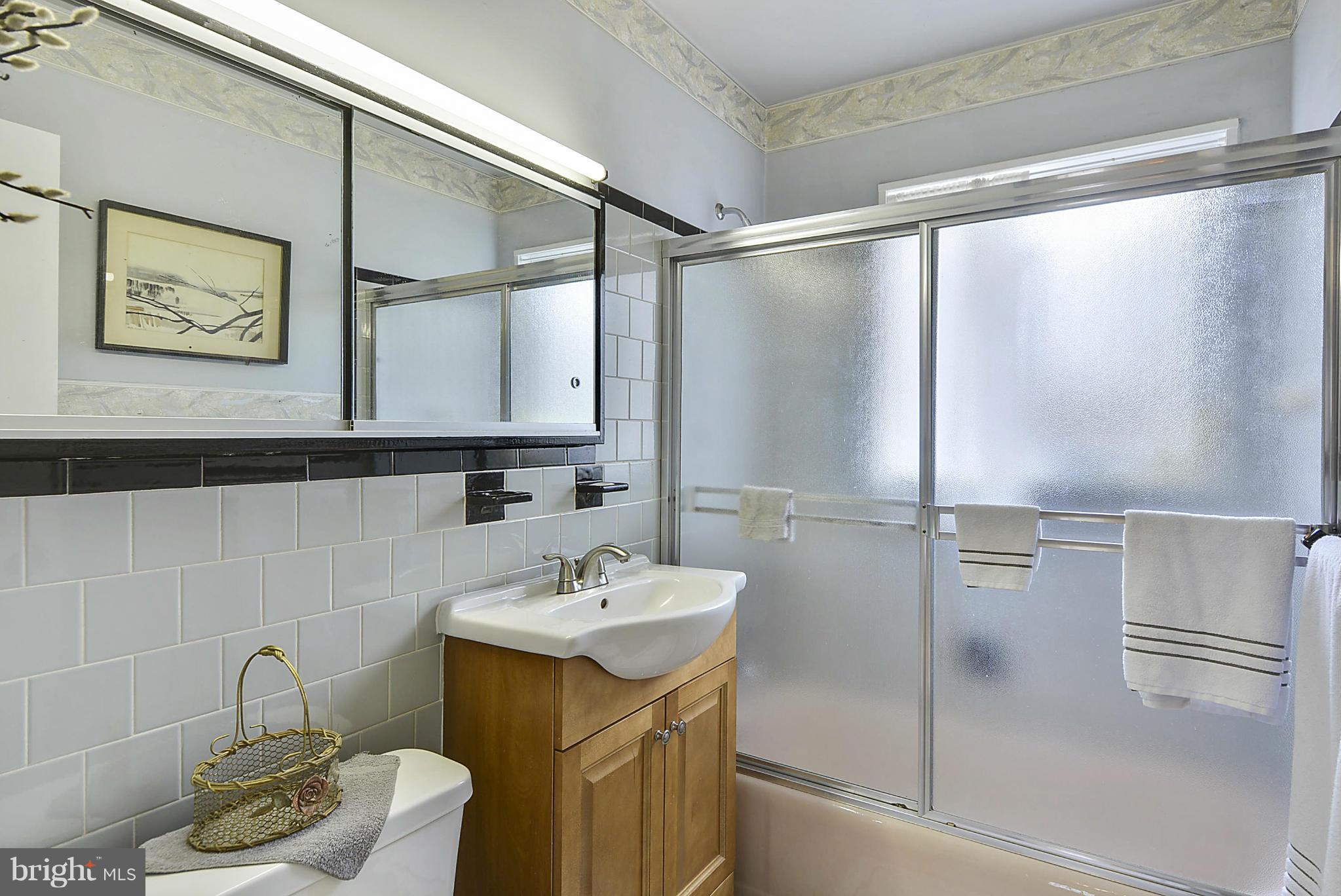 7405 Chatham Street Springfield, VA 22151 - Photo 23 of 30 a bathroom with a sink and mirror with toilet