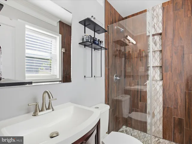 a bathroom with a sink a toilet and shower