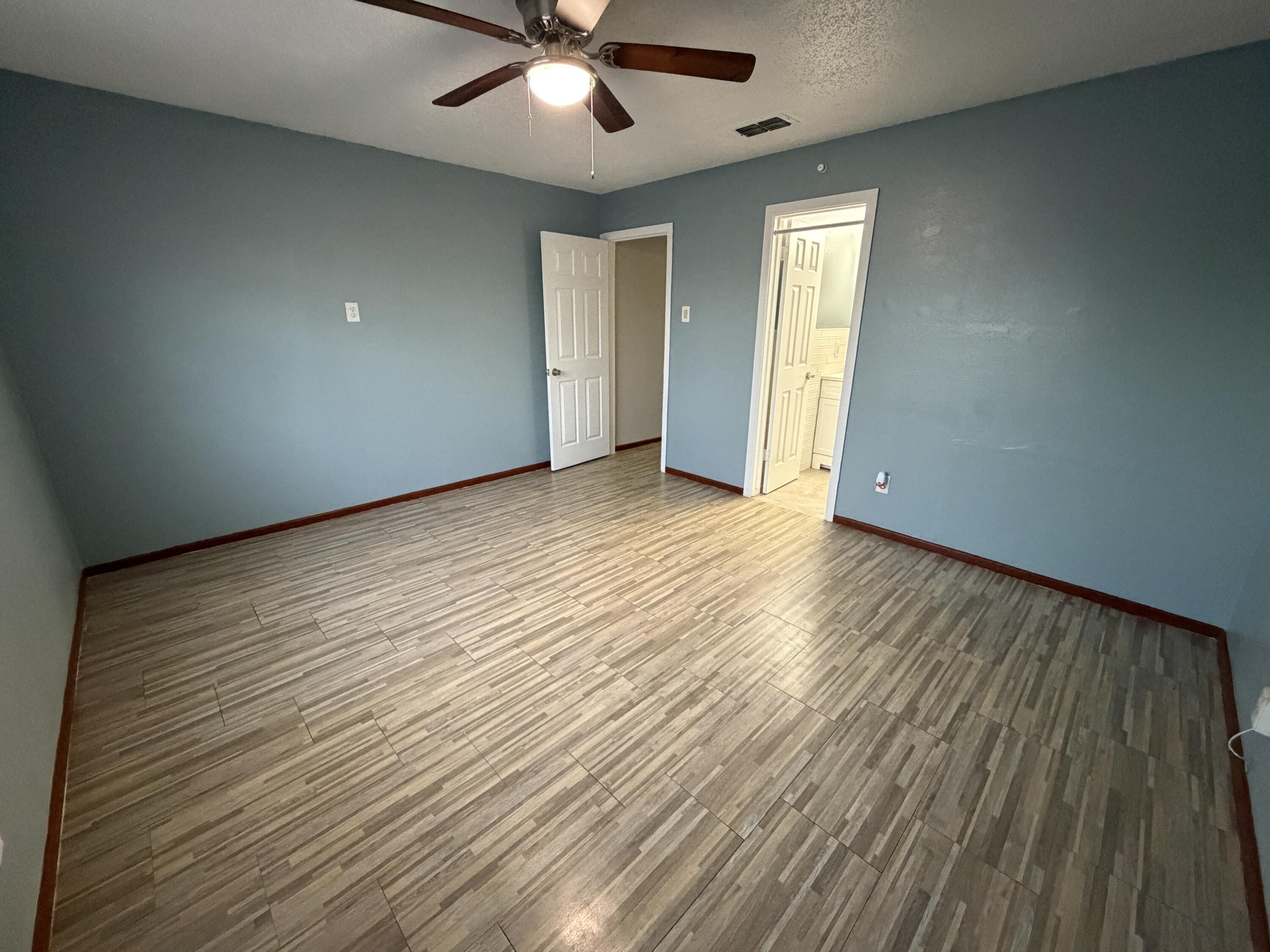 5720 46th Street Lubbock, TX 79414 - Photo 13 of 23 an empty room with wooden floor and windows