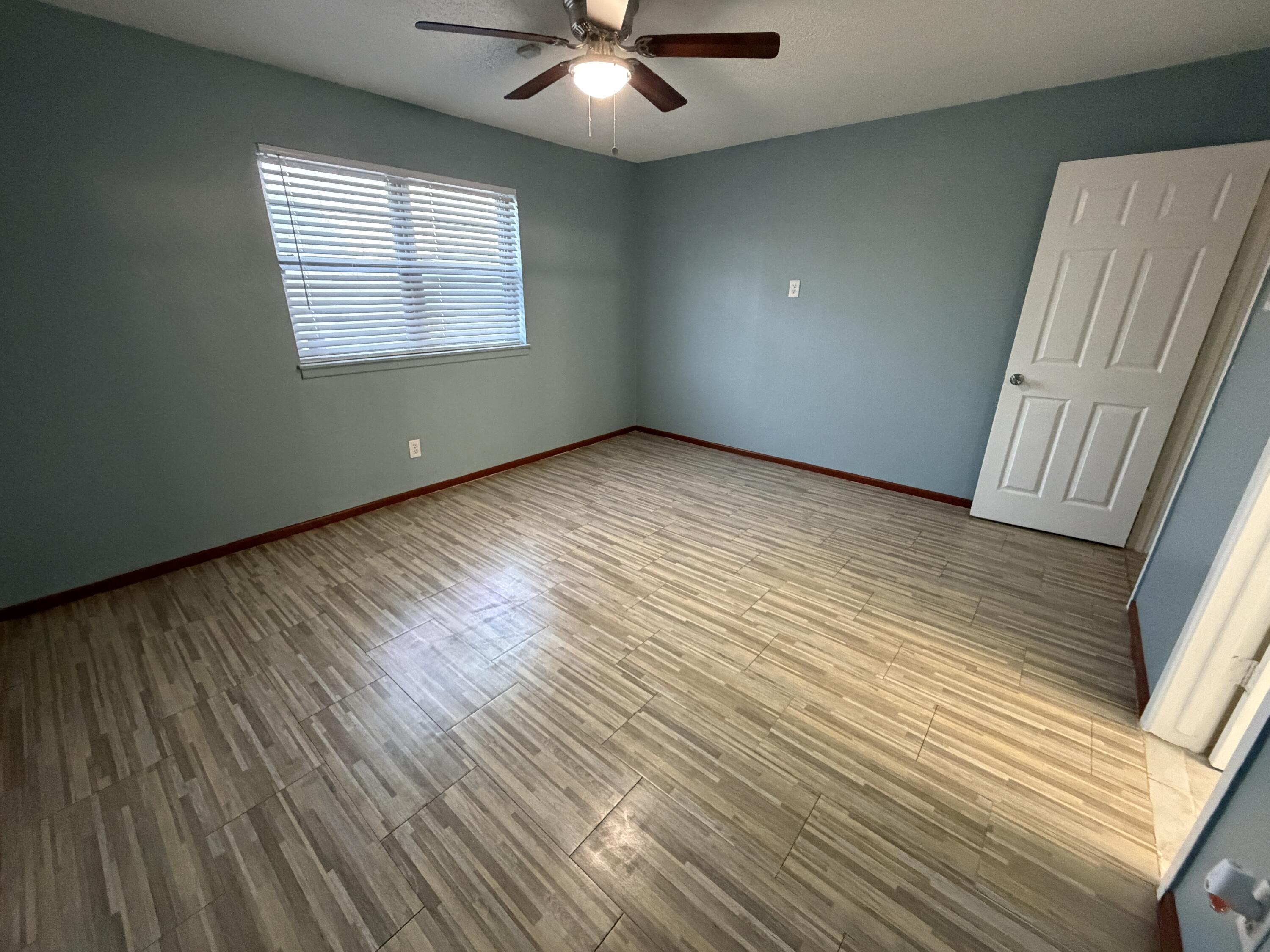 5720 46th Street Lubbock, TX 79414 - Photo 14 of 23 an empty room with wooden floor and windows