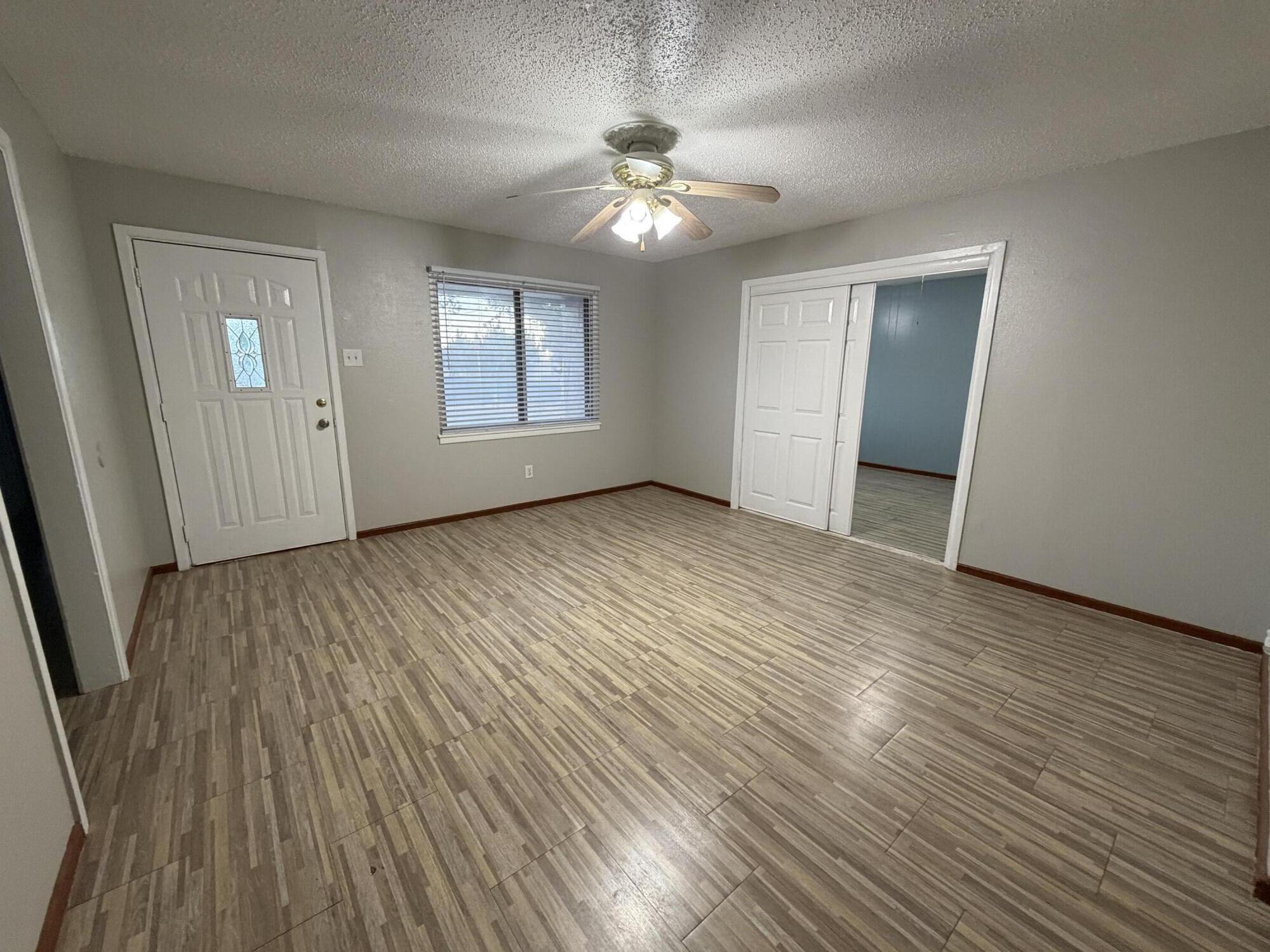 5720 46th Street Lubbock, TX 79414 - Photo 3 of 23 a view of a livingroom with wooden floor and a ceiling fan