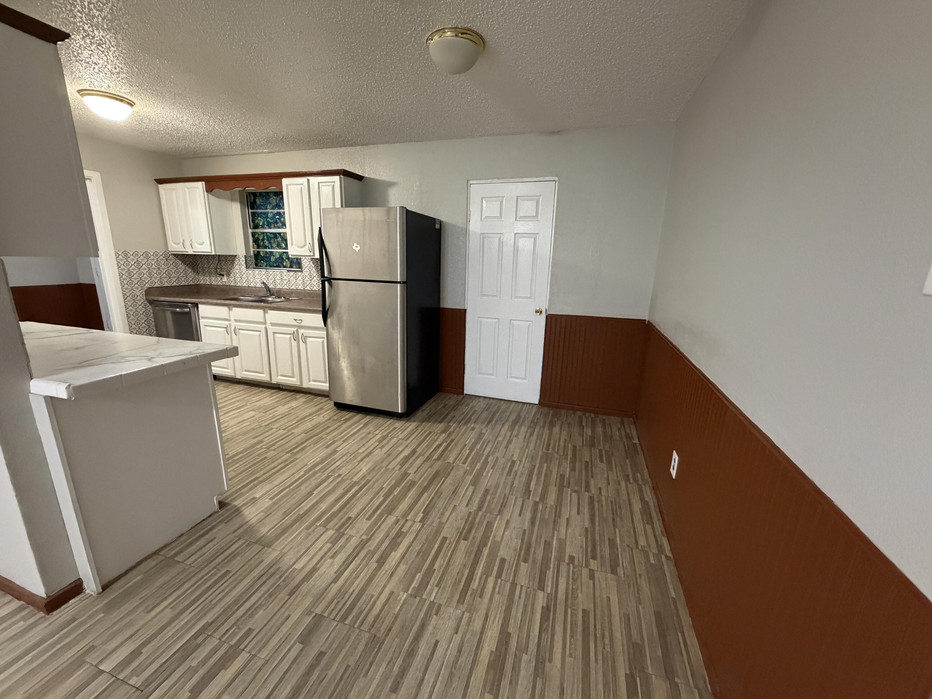 5720 46th Street Lubbock, TX 79414 - Photo 4 of 23 a kitchen with wooden cabinets and refrigerator